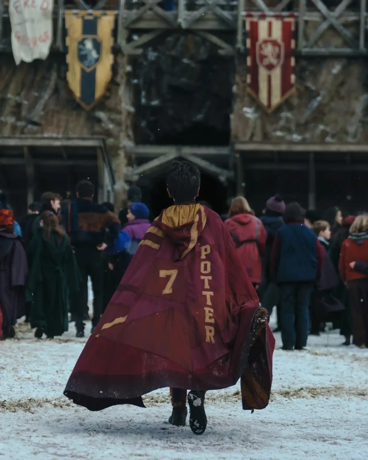 Segundo avance de Harry Potter y la piedra filosofal: Así luce la serie de 8 episodios de HBO Dominic McLaughlin de espaldas con la túnica roja con su apellido de personaje "Potter" y el número 7 en letras amarillas mostaza.